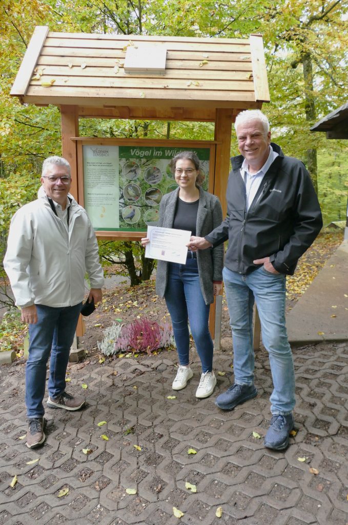 Drei Personen, zwei Männer und eine Frau vor dem Vogelstimmenspiel im Wildpark
